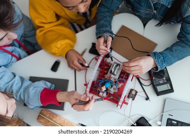 Group Of High School Students Building And Programming Electric Toys And Robots At Robotics Classroom