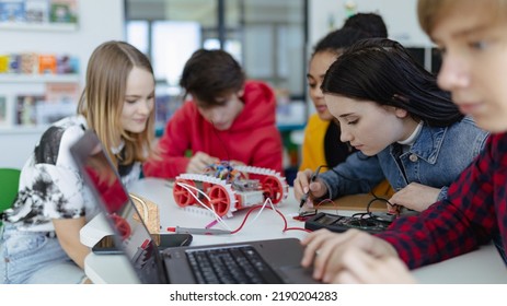 Group Of High School Students Building And Programming Electric Toys And Robots At Robotics Classroom