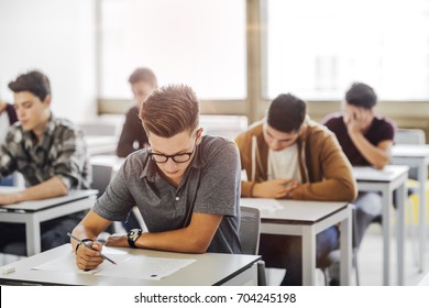 Group of high school students doing exam at classroom. - Shutterstock ID 704245198