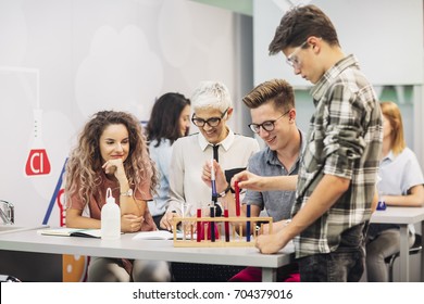 Group of high school students doing science experiments with their chemistry teacher and looking happy.