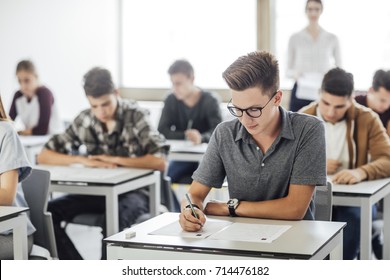 Group of high school students having test at classroom.