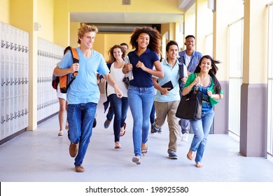 Group Of High School Students Running In Corridor