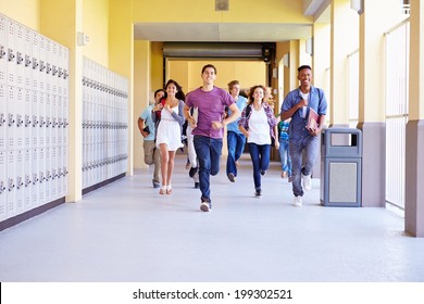 Group Of High School Students Running In Corridor