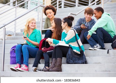 Group Of High School Students Sitting Outside Building