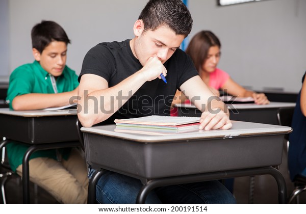 Group of high school students taking notes and\
studying in a classroom