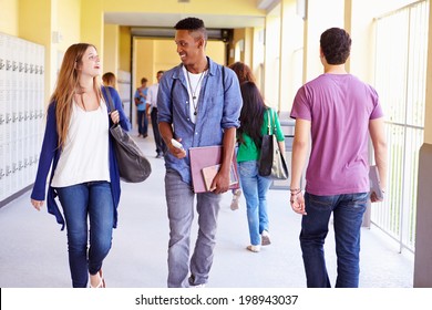 Group Of High School Students Walking Along Hallway