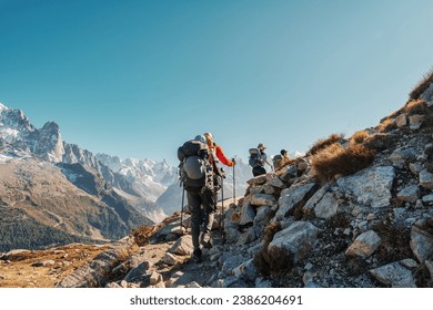 Group of hiker hiking on mountain trail with difficult to Lac Blanc amidst French alps on sunny day at France
