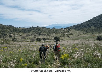 group of hiker walking passing through the flower field towards to the historical ruins in turkey. caria way, lycian way  - Powered by Shutterstock