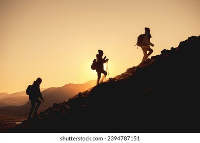 Group of hikers with backpacks walks uphill in sunset mountains - Powered by Shutterstock