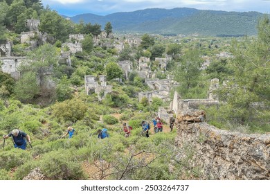 group of hikers traverses through lush greenery and ancient ruins, surrounded by a mountainous landscape. The atmosphere is serene as they explore the remnants of stone structures and overgrown  - Powered by Shutterstock