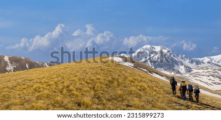 group of hikers walk over the mountain pass, mountain hiking scene