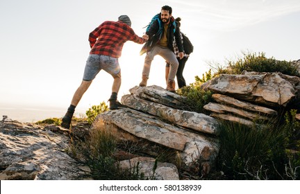Group Of Hikers Walking In The Nature At Sunset. Friends On Mountain Hike.