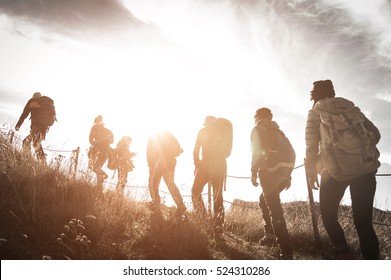 Group of hikers walking on a mountain at sunset - Shutterstock ID 524310286