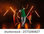 Group of hip hop dancer dancing together in a moody studio with tube neon lights.