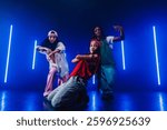 Group of hip hop dancer dancing together in a moody studio with tube neon lights.