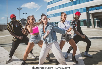 Group of hip hop dancers permorming their dance. Crew making show in an urban place - Powered by Shutterstock