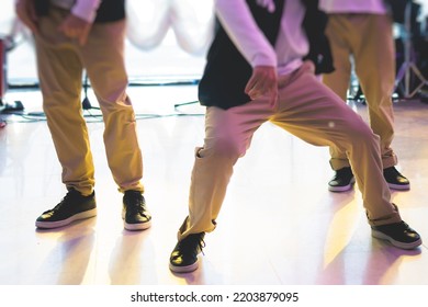 Group Of Hip-hop Dancers Performance On A Stage, Modern Contemporary Street Dance With Break Dancing In Studio, Hip Hop Dance Training  In A Ballroom, Legs In Sneakers Close Up