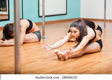 Group Of Hispanic Women Stretching And Warming Up For Their Pole Dancing Class