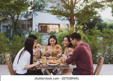 Group Holiday Party Of Asian People Eating Dinner And Drinking Beer At Home