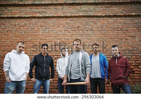 Group of hooligans or rappers on background of brick wall