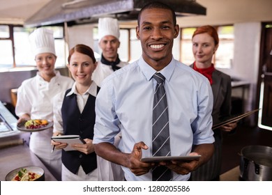 Group Of Hotel Staffs Working In Kitchen At Hotel