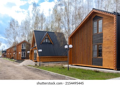 A Group Of Houses In The Same Style. Trendy Modern Barnhouse Style Houses. Bright Blue Sky