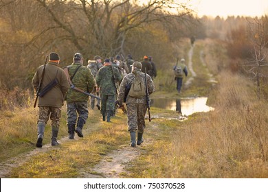 Group of hunters during hunting in forest. chase hunting. Hunter with weapon.
Hunter with friends. Hunters walking in the forest. hunters on hunting in the fall. hunter at dawn.