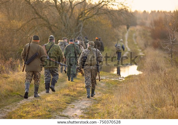 Group of\
hunters during hunting in forest. chase hunting. Hunter with\
weapon.\
Hunter with friends. Hunters walking in the forest.\
hunters on hunting in the fall. hunter at\
dawn.