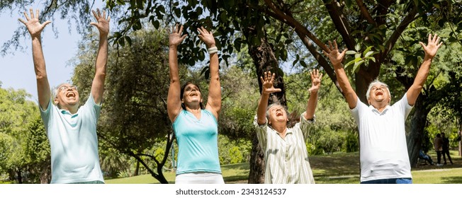 Group of Indian seniors doing laughing yoga together in park , Senior lifestyle concept  - Powered by Shutterstock