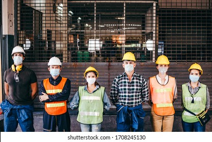 Group of industrial or engineer corporate workers wear protective mask and hard hat helmet standing line up in front of factory lock down prevention for Coronavirus or COVID-19 epidemic outbreak