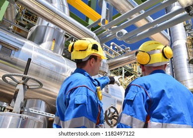group of industrial workers in a refinery - oil processing equipment and machinery 