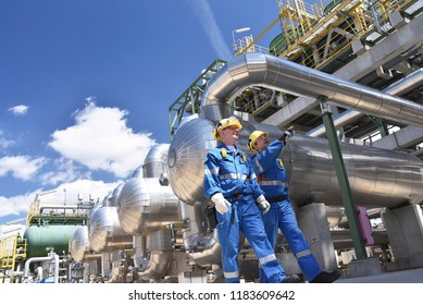 group of industrial workers in a refinery - oil processing equipment and machinery  - Shutterstock ID 1183609642