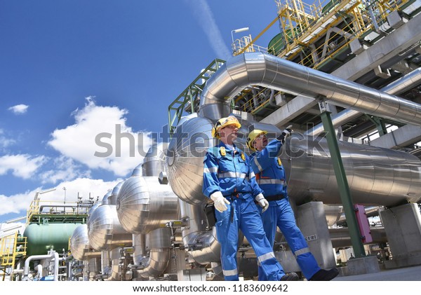 group of industrial workers in a refinery -\
oil processing equipment and machinery\
