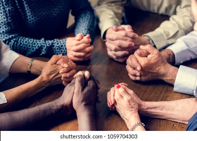 Group of interlocked fingers praying together - Shutterstock ID 1059704303