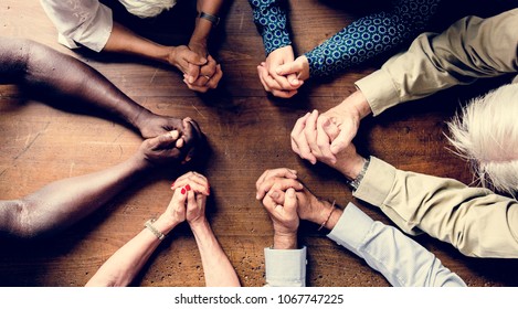 Group Of Interlocked Fingers Praying Together