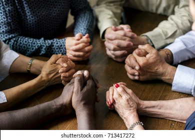 Group of interlocked fingers praying together - Shutterstock ID 713417272