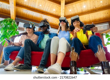 Group Of International Friends Wearing A New Futuristic Virtual Technology With Headsets While Sitting On Couch - Team Of Creative Friends Working A Futuristic Project With Goggles In AR