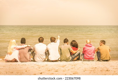 Group of international multiracial friends sitting at the beach talking with each other and contemplating the sea - Concept of multi cultural friendship against racism - Warm vintage filtered look - Powered by Shutterstock