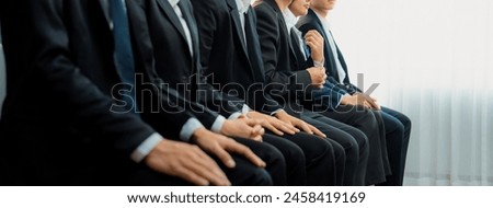 Group of interviewee candidate in formal suit line up for interview sitting on the chair. Job opportunity recruitment for HR agency and vacancy concept. Shrewd