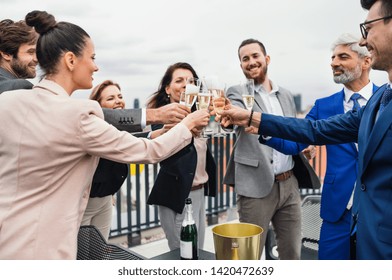 A group of joyful businesspeople having a party outdoors on roof terrace in city.