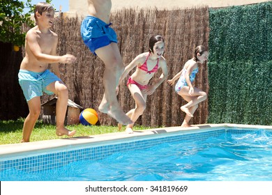 Group Of Joyful Children Jumping In A Swimming Pool In A Home Garden On A Sunny Summer Holiday, Having Fun Being Energetic Outdoors. Active Kids Lifestyle, Playing In House Exterior On Vacation.