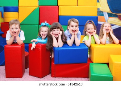 Group Of Joyful Kids Hiding Behind Large Leather Blocks