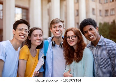 Group Of Joyful Multiethnic Students Posing Smiling To Camera Standing Near College Building Outside. Higher Education Concept