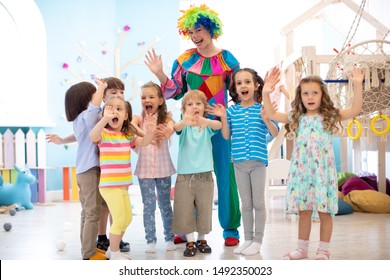 Group Of Joyful Preschool Kids Play With Clown On Birthday Party