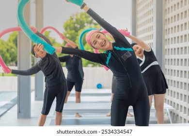 group of joyful seniors participates in a fun water exercise class outdoors, using colorful pool noodles for stretching and balance. They are engaged in a fitness routine, staying active and healthy. - Powered by Shutterstock