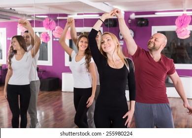 Group Of Joyful Smiling Young Adults Dancing Salsa At Dance Class