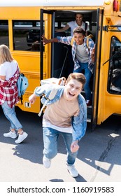 Group Of Joyful Teen Scholars Running At School From Bus