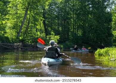 Group kayak trip for seigneur and senora . An elderly couple And adult rowing boat on the river, a water hike, a summer adventure. Age-related sports, mental youth and health, tourism, active old age - Powered by Shutterstock