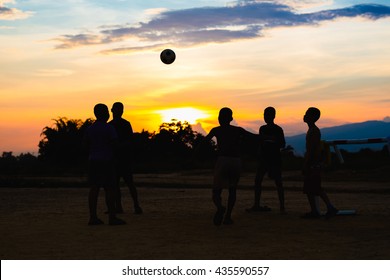 Group of the kids (boys) are playing soccer football for exercise in the sunshine day.. The silhouette picture style.