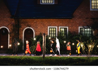 Group of kids with Halloween costumes walking to trick or treating - Shutterstock ID 1186744279